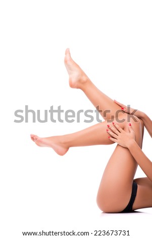 Half-length portrait of woman wearing black lingerie lying on the back pulling up her perfect legs isolated on white background