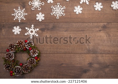 Christmas tree toys  and decoration like  wreath of fir branches and apples and cones   and on wooden table with white  snowflakes with   top view  and  copy place