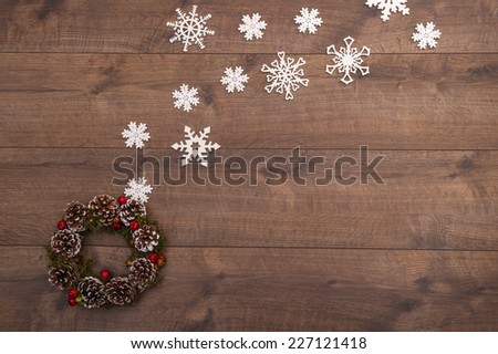 Christmas tree toys  and decoration like  wreath of fir branches and apples and cones   and on wooden table with white  snowflakes with   top view  and  copy place