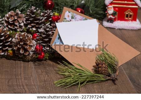 Christmas tree toys and  decoration like envelope with white clear sheet of paper  and fir branch on wooden table