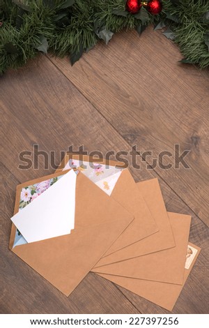 Christmas tree toys and  decoration like envelopes with white clear sheet s of paper  and fir branch on wooden table top view  with copy place