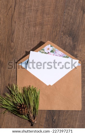 Christmas tree toys and  decoration like envelope with white clear sheet of paper  and fir branch on wooden table top view  with copy place