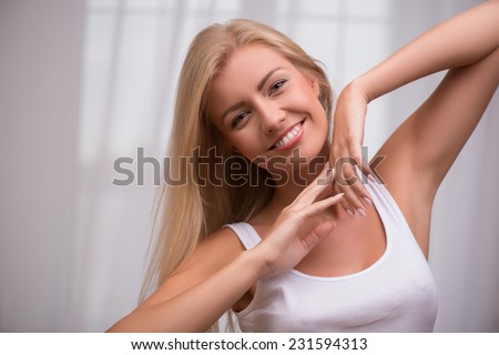 Portrait of beautiful blond girl with green  eyes  and straight  hair in white  T shirt  looking at camera smiling   with copy place
