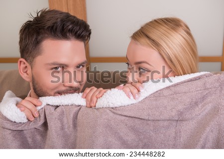 Portrait of happy couple in love of handsome man looking at camera   and attractive woman looking  out spread with frightened  eyes