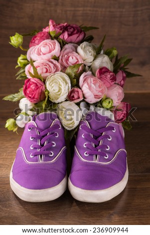 cool youth violet   shoes near bunch of roses on brown parquet  wooden floor