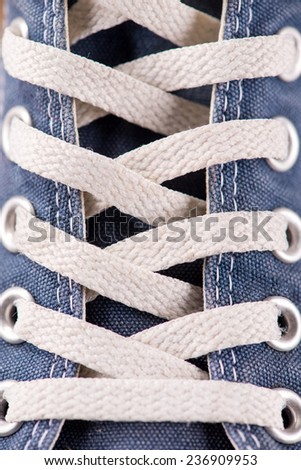 cool youth blue gym shoes with white laces  on brown parquet  wooden floor close up