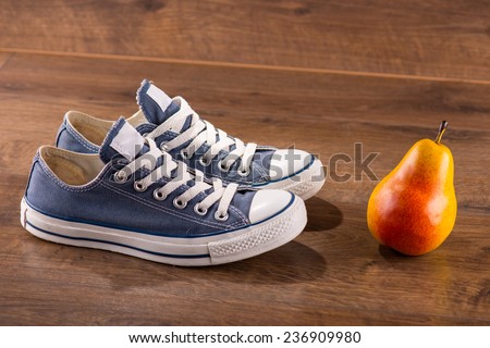 cool youth blue gym shoes with white laces  on brown parquet  wooden floor with pear