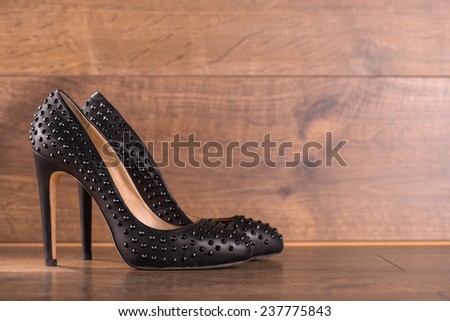 black classic  high heeled refined  black patent leather shoes  on brown parquet  wooden floor with copy place