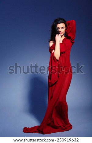 Beauty in marsala dress. Full-length fashion image of beautiful young woman in trendy marsala dress standing on dark blue background