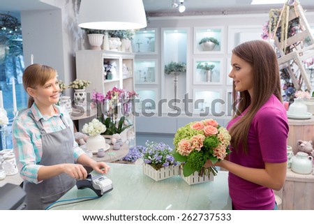 Easy payment procedure. Conversation between customer and florist making a purchase via point of sales terminal