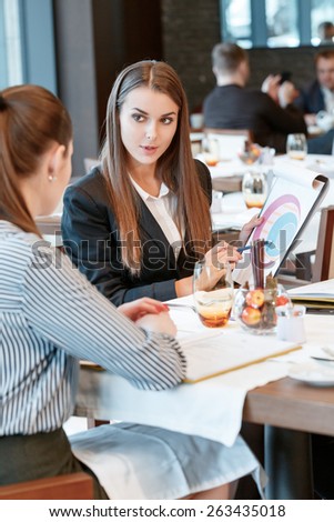 This data show real progress in business dynamics. Vertical shot of a young beautiful businesswoman showing a clipboard with the diagram to her colleague