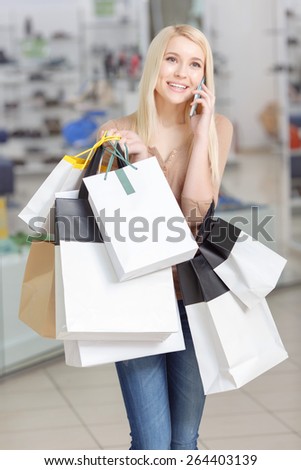Best time for shopping. Beautiful blond woman holding shopping bags copy space and talking over the phone