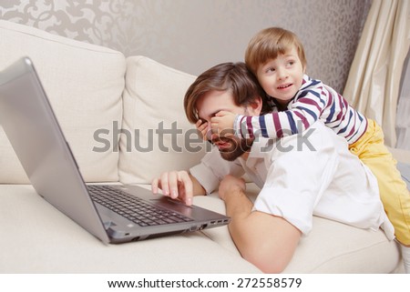 Do not watch.  Small boy clothing eyes to his father with hands so that he could not see the screen of a laptop