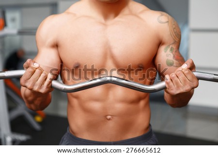 Massive job. Close up of workout of weightlifter with really good body in sport gym club.