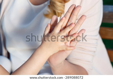 Funny game. Close up portrait of mother and daughter playing patting cake.