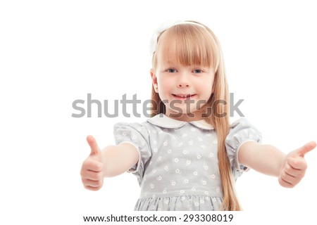 Life is good. Happy nice little  girl thumbing up and smiling while standing isolated on white background