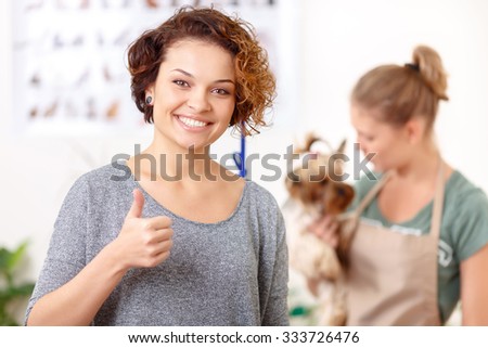 Cheering up. Smiling radiant young woman looks content and showing thumbs up.