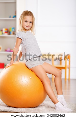 Physical activities. Little girl is getting ready to do some physical exercises.