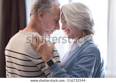 Happy aged couple dancing at home