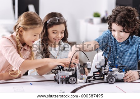 Cheerful kids working on the tech project at school