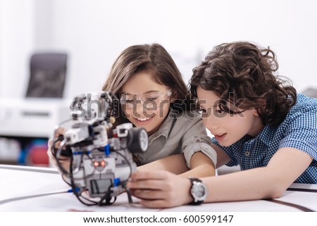 Curious kids playing with robot at school