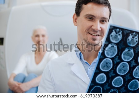 Happy positive doctor holding CT scan results