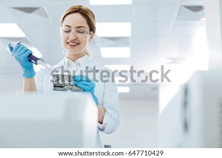 Positive delighted female scientist doing experiment