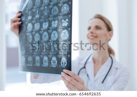 Cheerful medical specialist examining x ray at the laboratory