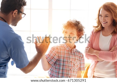 Handsome teenager giving high-five to his friend
