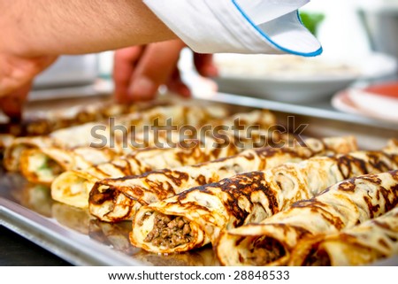 Chef cooking pancakes with meet inside