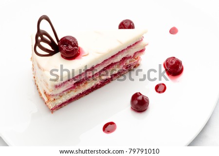 Fresh baked delicious white sponge-cake with cherry on top