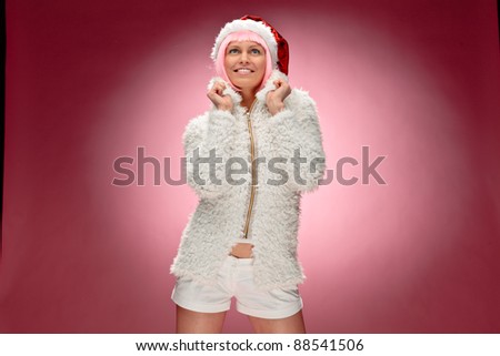 Portrait of a beautiful young woman in pink wig wearing xmas clothes over red background.