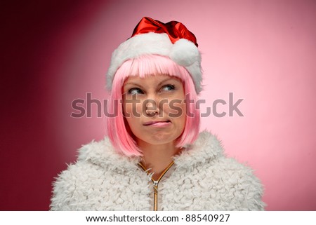 Portrait of a beautiful young woman in pink wig wearing christmas clothes over red background.