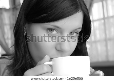 Young lady drinking a cup of coffee (black and white photo)