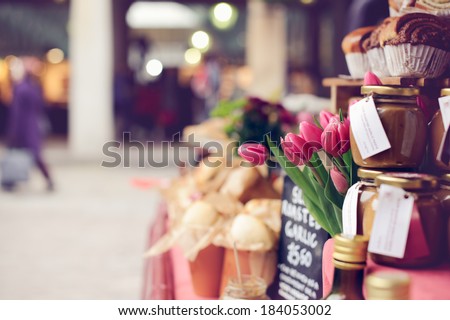 Pink tulips, baked goods, homemade preserves and jams on a farmer\'s market stand
