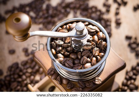 A coffee grinder and coffee beans with natural light