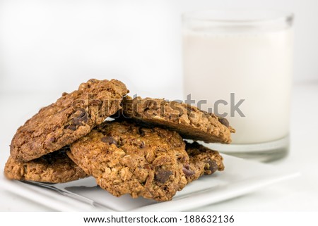 Freshly baked vegan chocolate chip cookies and a glass of almond milk.