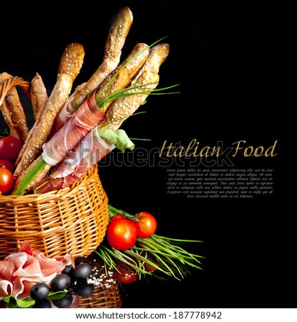 Grissini with prosciutto crudo and vegetables in basket