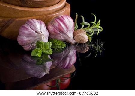 Garlic and herbs with reflection isolated on black