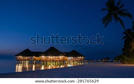 Night shot of an over-water restaurant of an island resort in Maldives