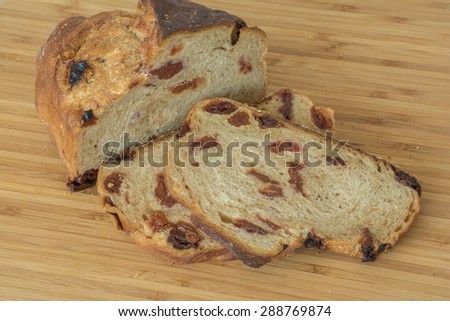 Loaf of cherry bread and slices of gourmet baking for snack on wood board