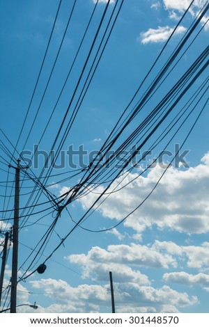 Telephone towers with connecting cables / lines against blue sky background. Communication technology