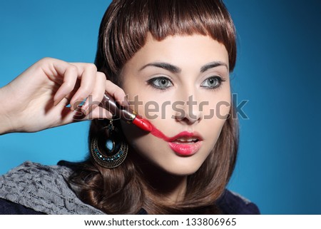 girl smearing lipstick on face