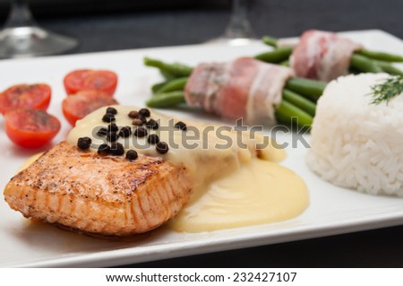 salmon steak with hollandaise sauce and rice cherry tomatoes and green beans