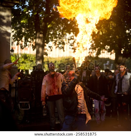 Paris, France - October 13  2012: People with fire  as a zombie parades on a street during a zombie walk in Paris.