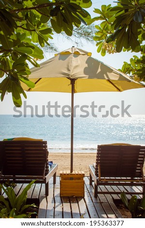 Beach chairs under tree or umbrella shade by the ocean environments in sunny day.