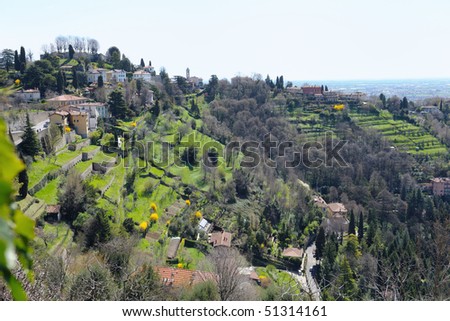 View over terraced gardens to San Vigilio, Bergamo, Lombardy, Italy, Europe.  The remains of the Medieval castle are visible on its summit.