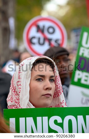 LONDON, ENGLAND, UK - NOV 30: An unidentified public sector worker with Unison trades union sign, listenes to speeches after the N30 march in support of  strikes over pension cuts in Victoria Embankment, London, England, UK on Nov. 30, 2011.