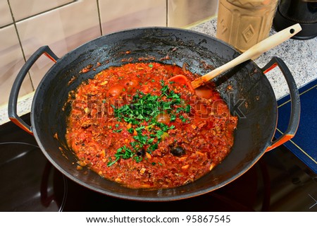 Bolognese sauce cooking in a wok on an induction cooker