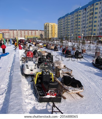 Nadym, Russia -  March 17, 2006: the national holiday, the day of the reindeer herder in Nadym, Russia -  March 17, 2006. Snowmobiles parked on the roadside.